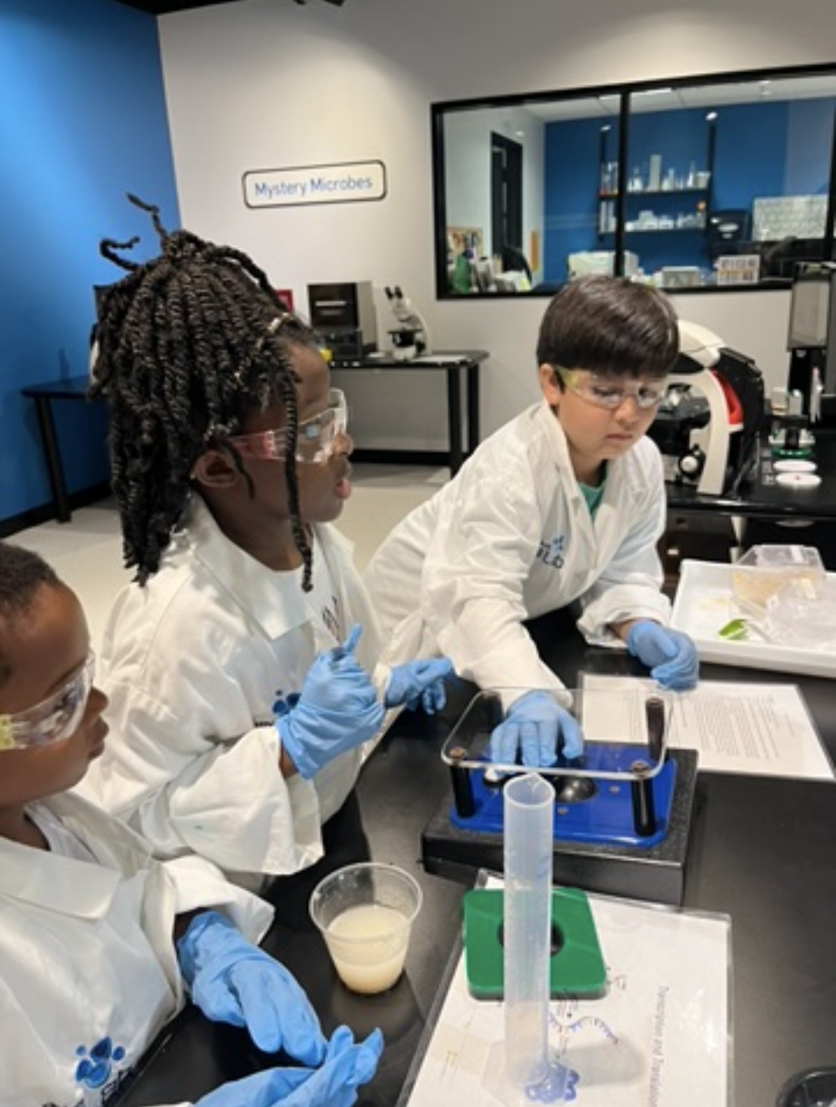Students in lab coats running a science experiment