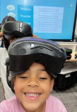 A smiling student wearing a VR headset